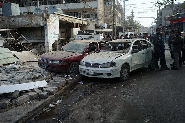 People inspect the scene of where an explosion occurred earlier, in Baghdad, Dec. 22, 2011. (Michael Kamber/The New York Times)